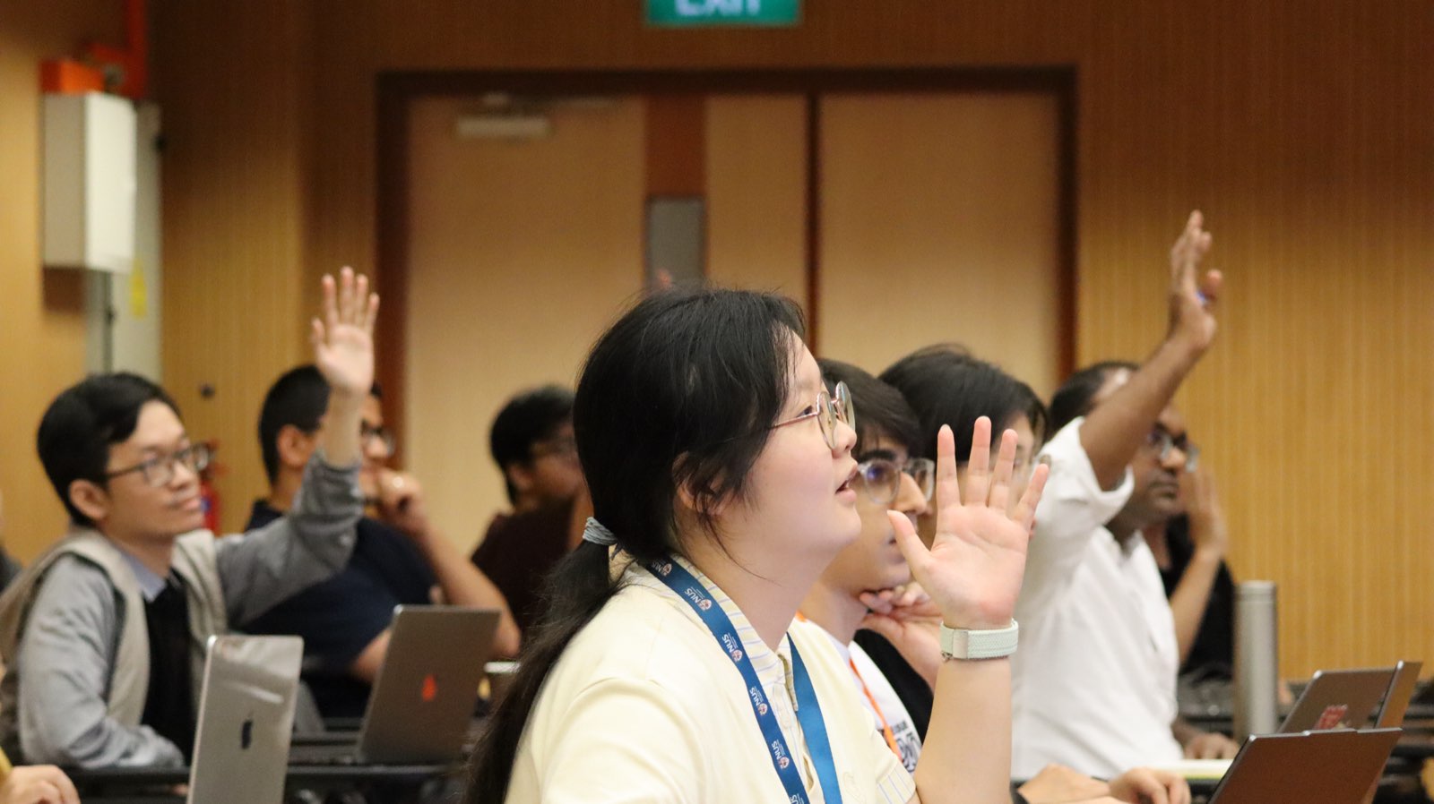 Audience members raising hands during Q&A