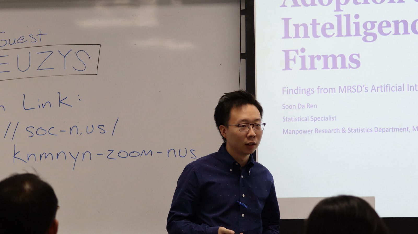 Speaker presenting beside a whiteboard